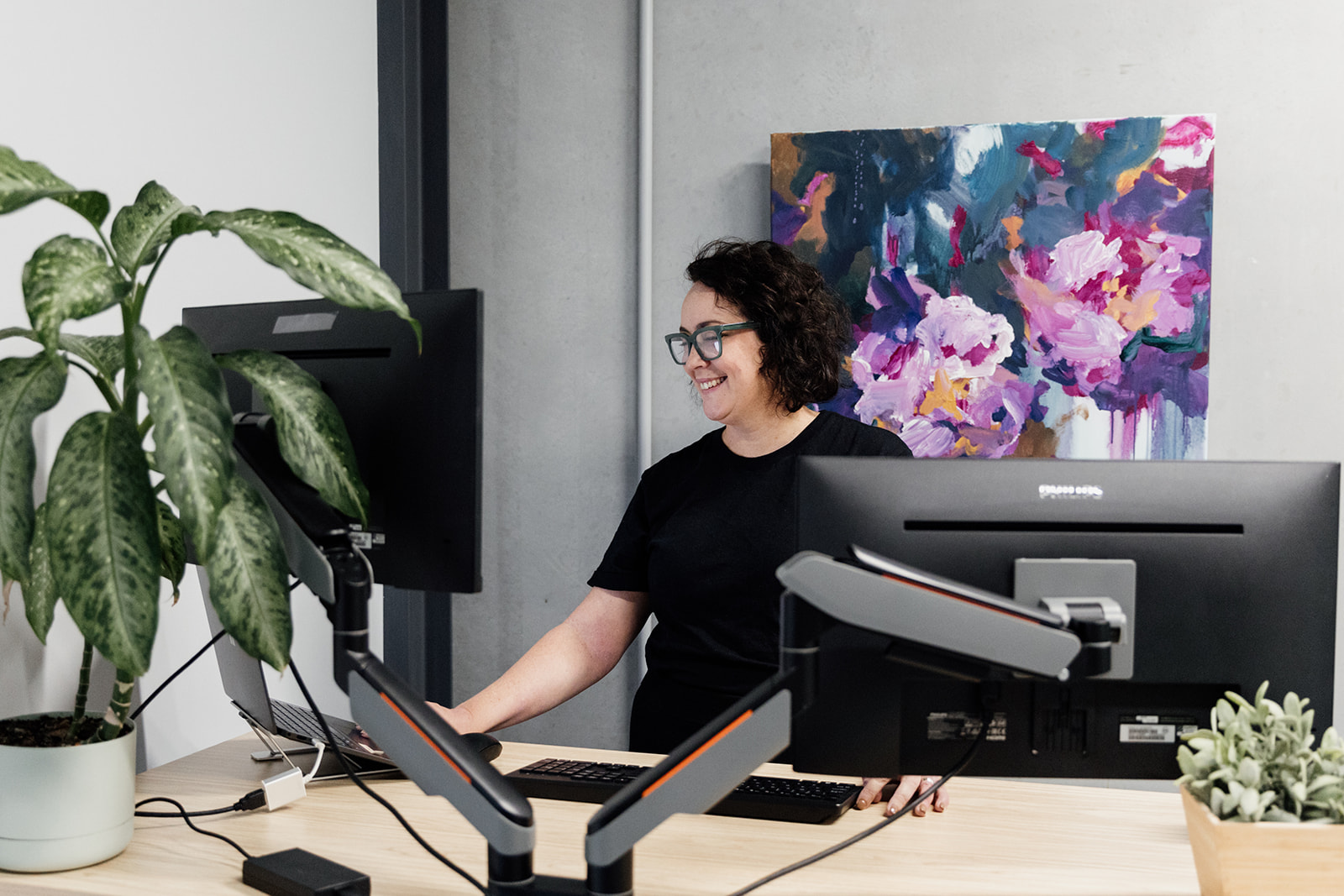 Julia Fiore of Seed People Consulting working at her dual-monitor workstation — an example of a well-designed role and work environment.